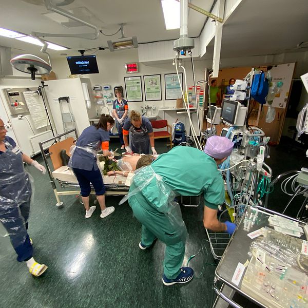 Fyra läkare står över en patient i ett akutrum under en katastrofövning på sjukhuset.