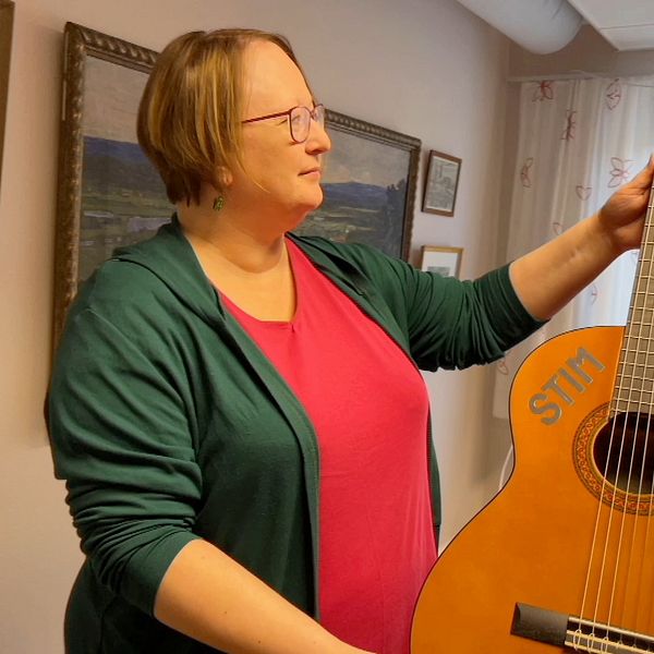 bibliotekssamordnaren i Malun-Sälen, Jenny Oskarsson, håller upp en gitarr som kommer från Stim.