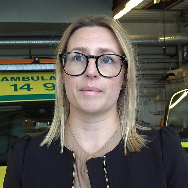 Verksamhetschef Lina Ideborg framför ambulans i garage