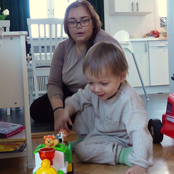 Föräldern Malin Åsells är kritisk mot nedläggningen av Karlavagnens dagverksamhet. Här leker hon med sonen Hannes på golvet.