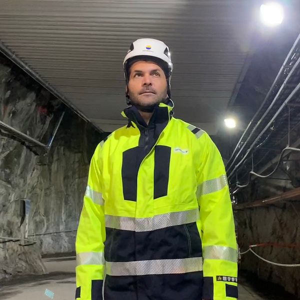 en man i varselkläder i ett bergrum