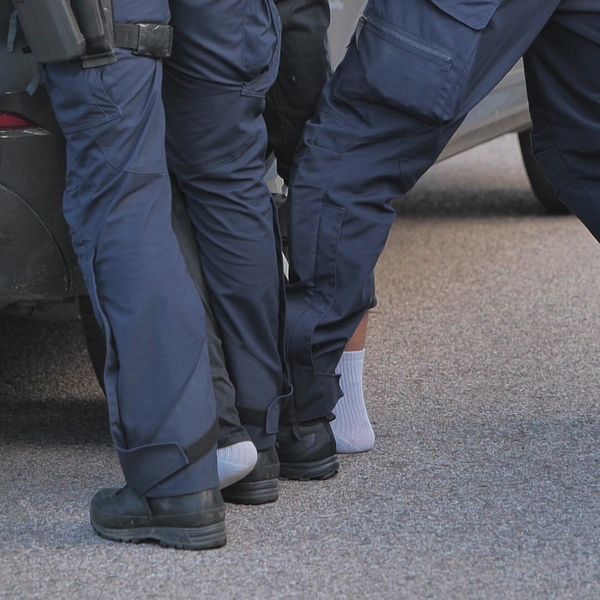 person blir frihetsberövad av två poliser