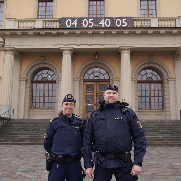 Två poliser står framför Carolina Rediviva i Uppsala och kollar in i kameran.