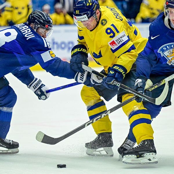 Kamp om pucken mellan tre spelare.