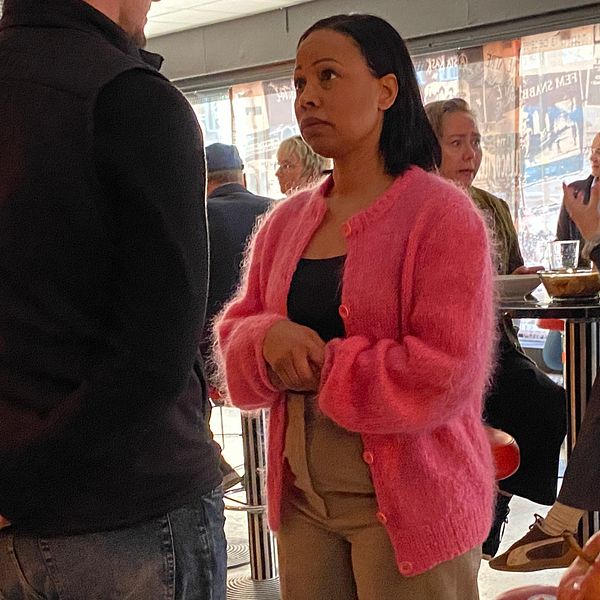 Alice Bah Kuhnke talar med ett par i ett kafé.