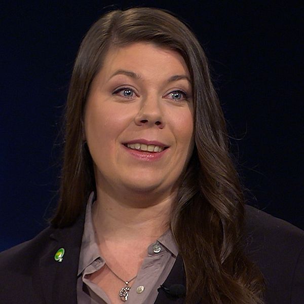 Miljöpartisten Elin Söderberg  iklädd en mörk kavaj med en grön partinål under en TV-sändning.
