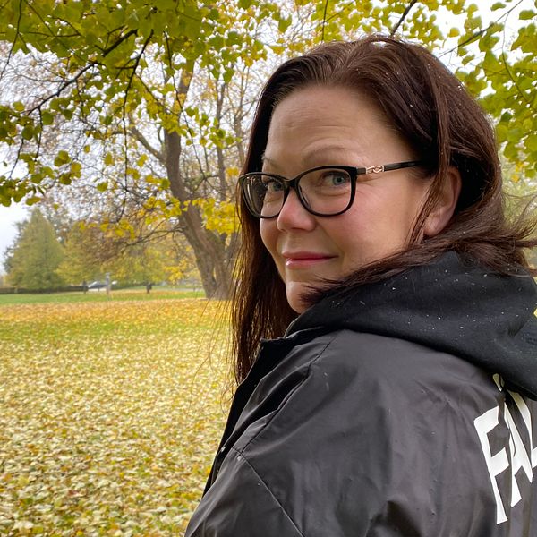 Linda Lindgren, teamledare för de fältande socialsekreterarna i Västerås, i jacka med texten ”Fält” i Vasaparken i Västerås på hösten