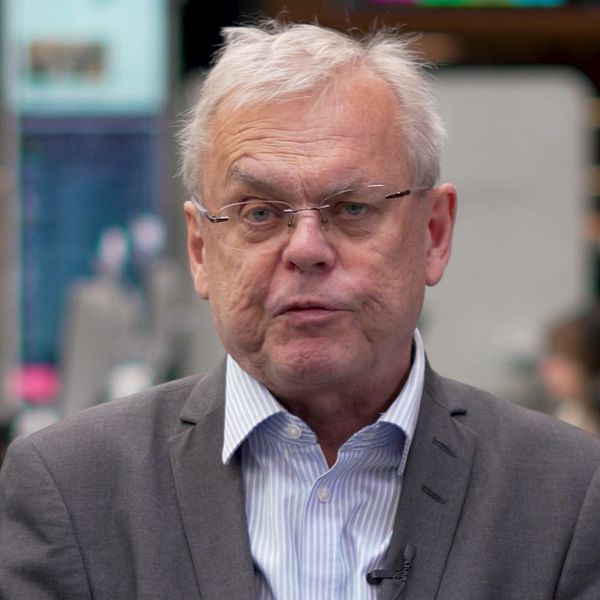 Man i kostym och skjorta intervjuas i en studiomiljö.