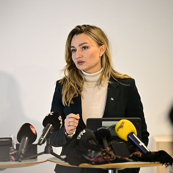 Ebba Busch talar vid presskonferens med flera mikrofoner framför sig.