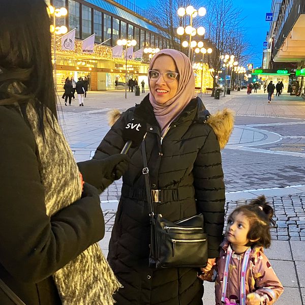en kvinna med sin dotter intervjuas av SVT reporter i Södertälje centrum