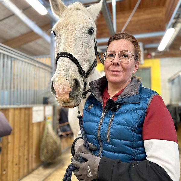 Verksamhetschef Camilla Granberg vid Umeå Ryttarförening håller i en vit häst