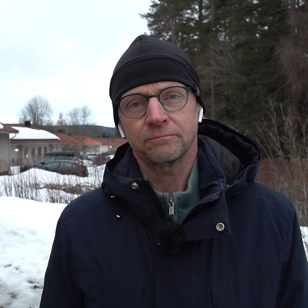 SVT:s reporter Fredrik Israelsson står utomhus i ett snöigt villaområde och direktrapporterar.