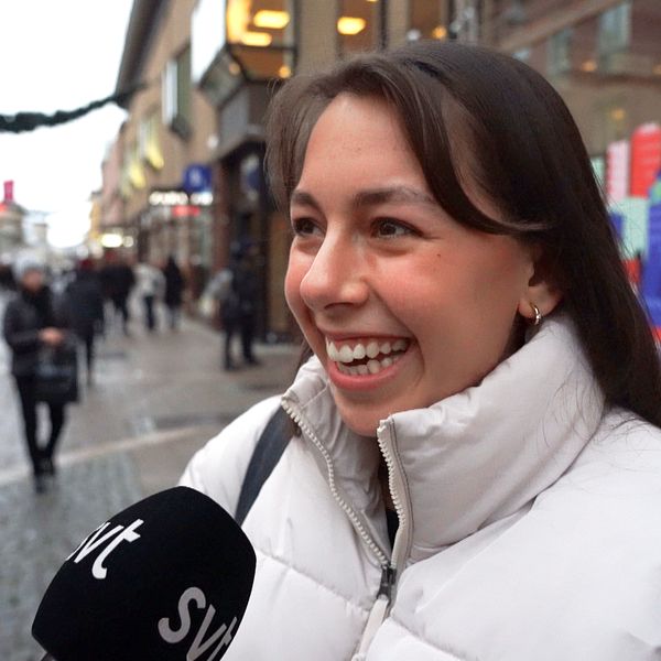 Ung leende kvinna i dunjacka