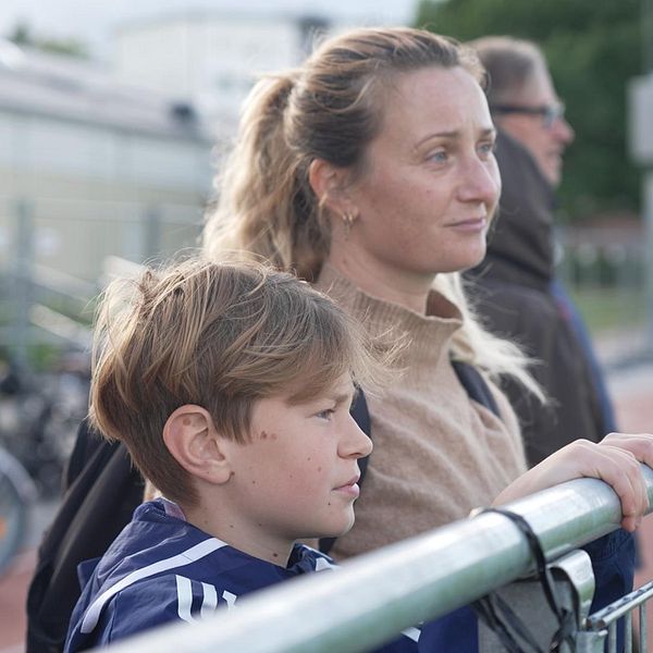 Fotbollsspelaren Ossian med sin mamma vid Mälarhöjdens IP som varit stängt efter dödsskjutningen. ”Jag tänker fortfarande komma hit för att spela”, säger Ossian Stridsman.