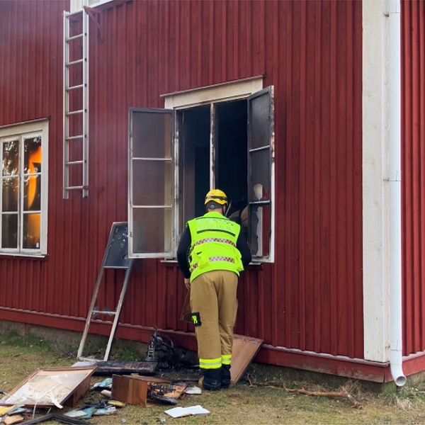 brand i rött hus med brandman