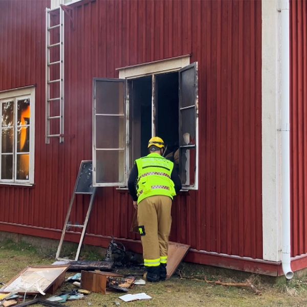 brand i rött hus med brandman