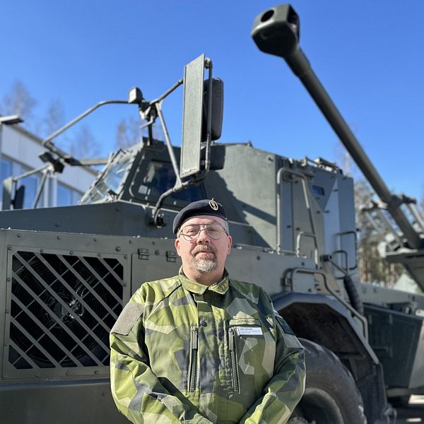 En man i uniform står framför artillerisystem Archer