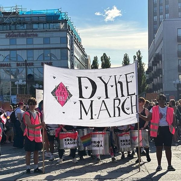 Demonstranter med Dyke March-banner på Medborgarplatsen i Stockholm