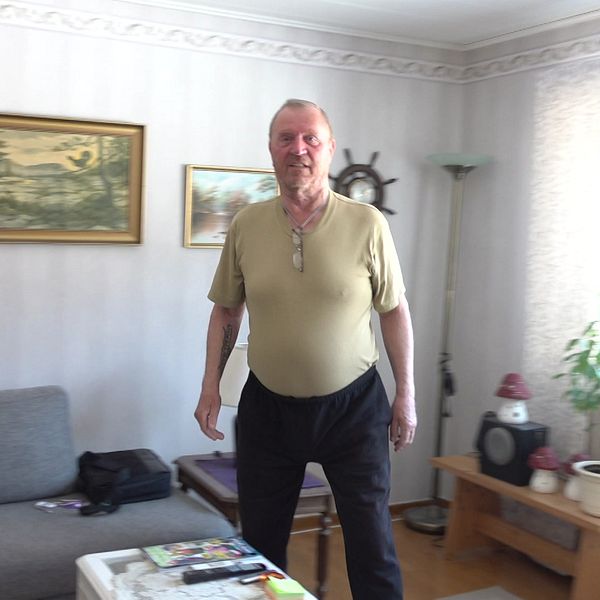 Tommy Broström står i sitt vardagsrum