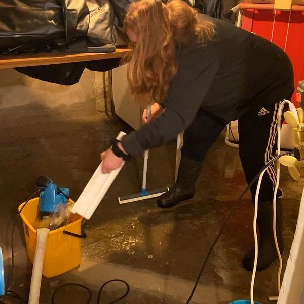 Ingrid Jernberg öser vatten från sin källare.