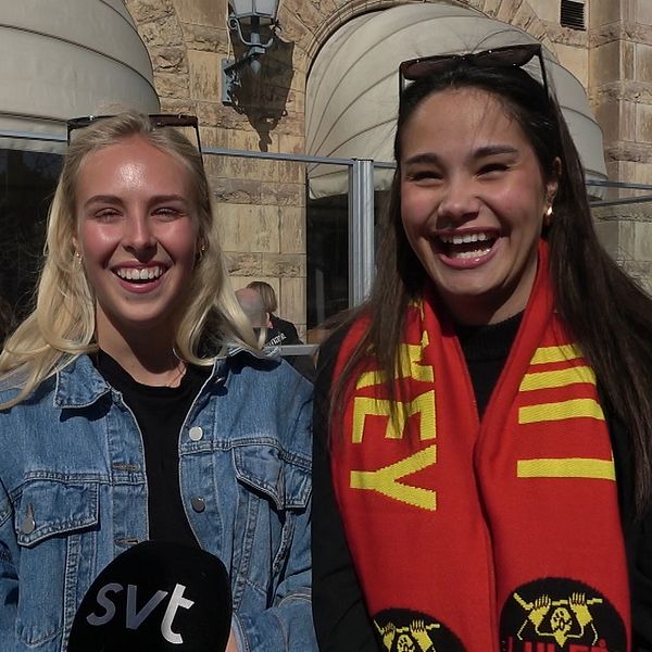 Två personer intervjuas utanför ett kafé, en bär supporterscarf och den andra SVT-mikrofon.