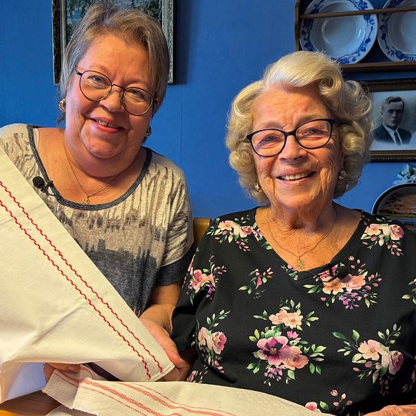 Ulla-Britt och Helena Haals sitter bredvid varandra och visar textilierna ur den första moderskapsförpackningen.