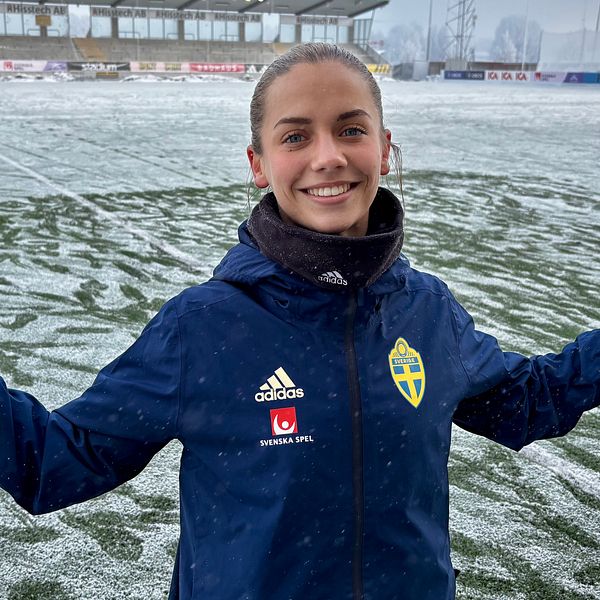Johanna Renmark i landslagsjacka på snötäckt fotbollsplan inför U23-landskamp i Västerås