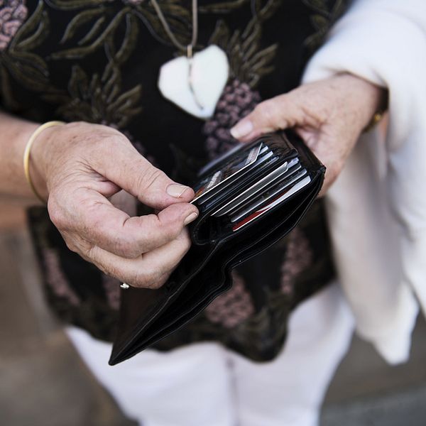 En kvinna håller i en plånbok med kreditkort