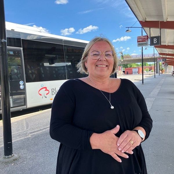 Kvinna som står framför en buss