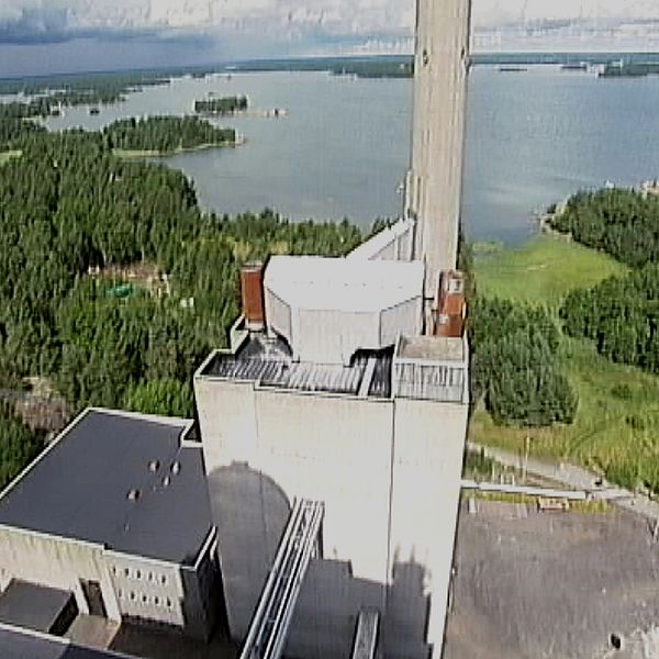 Kraftverket Marviken omgivet av skog och vatten med sjö i bakgrunden.