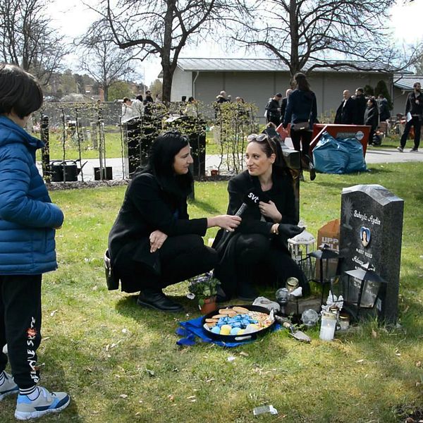 Annandag påsk firas på kyrkogården i Södertälje. En mamma sitter vid en grav med fika och godis, några barn står bredvid. .