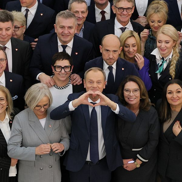 Donald Tusk gör handhjärta med polska parlamentariker.