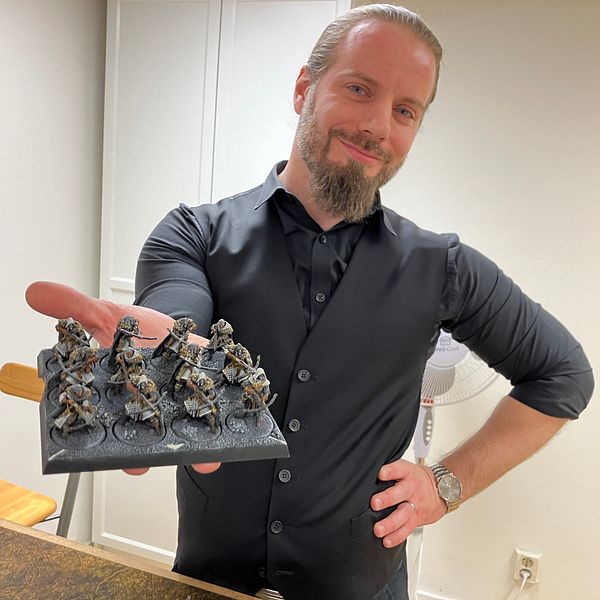 Västerås Wargamings ordförande visar upp ett bräde med spelfigurer.