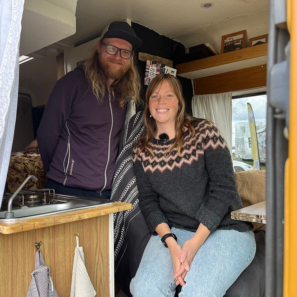 En man och en kvinna sitter i en campervan.