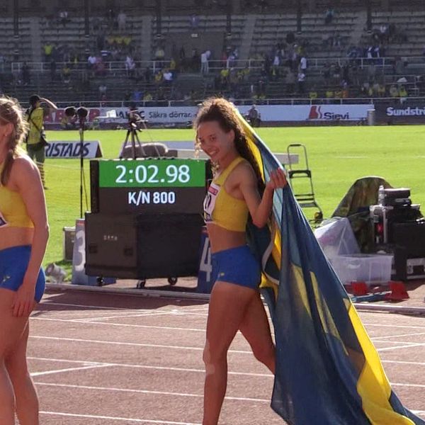Yolanda Ngarambe håller i svenska flaggan på löpbanan