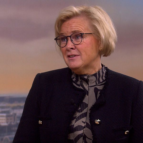 Kvinna i studio tittar snett framåt.