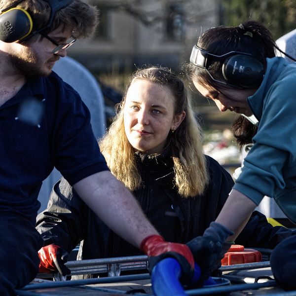 Tre personer som sitter på dunk