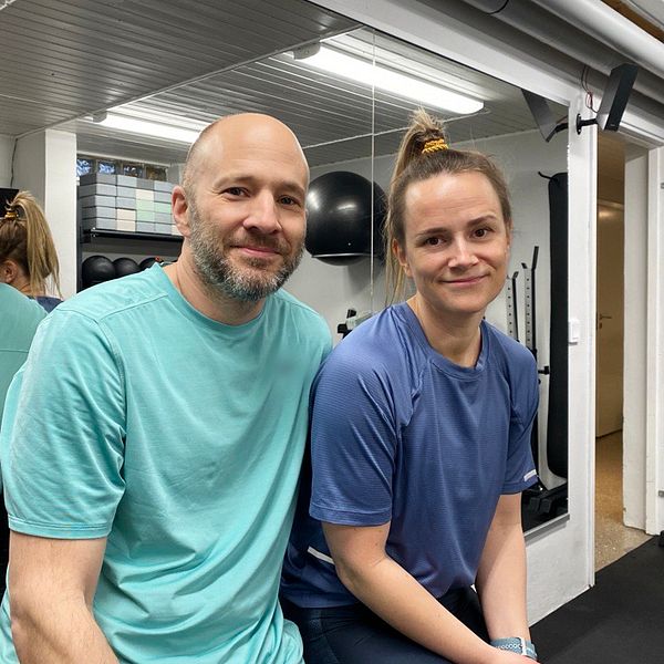 Maria och Fredrik Arvidsson sitter framför en spegel i sitt hemmagym i Eskilstuna.