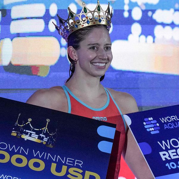 Kate Douglass firar med krona och prischeckar efter världsrekord på 100 meter fritt.