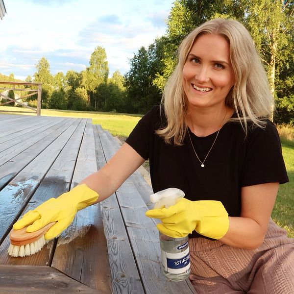 Ellinor Sirén som driver Ekotipset skrubbar verandan med ättika-medel.