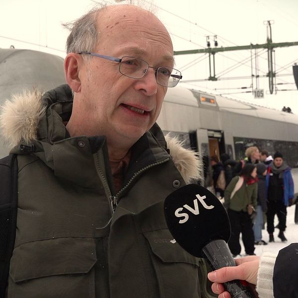 Arne Müller på tågperrongen framför ett tåg.