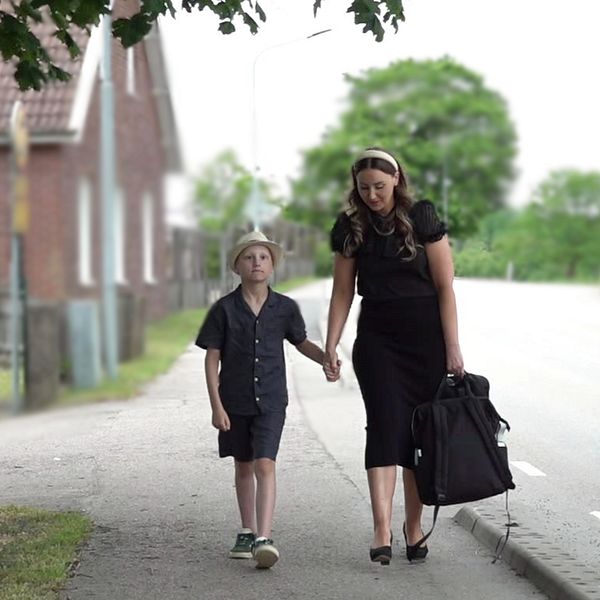 Eleven Wilhelm Dockenfelt, samt och mamma Emelie, går hand i hand förbi Oderljunga skola.