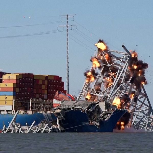 En bit av bron som ligger över ett containerfartyg sprängs