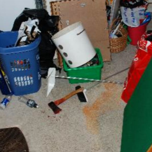 Det misstänkta mordvapnet – en blodig yxa – hittades på golvet i garaget.