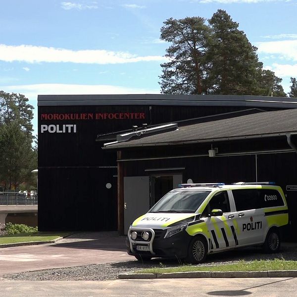 En polisbuss står parkerad utanför en byggnad vid Morokulien på gränsen mellan Sverige och Norge.