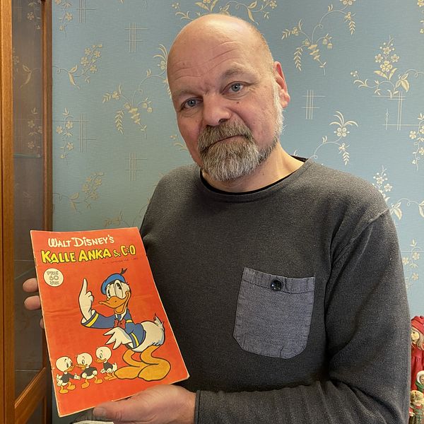 Magnus Christiansson håller upp en tidning med Kalle Anka från 1948.