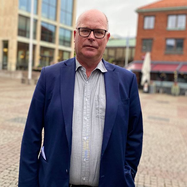 Man iklädd en skjorta och mörkblå kavaj