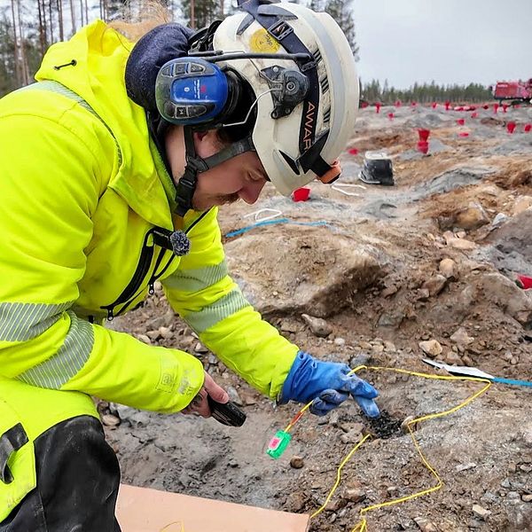 Arbetare förbereder sprängning vid E4 Sävar för Norrbotniabanan, trafik påverkas.