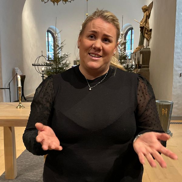 En kvinna längst fram i kyrkan.