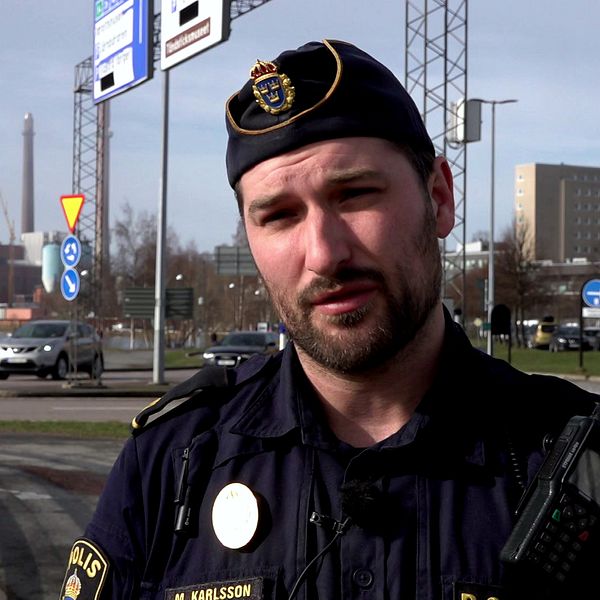 polisman med skägg iklädd uniform står vid en rondell